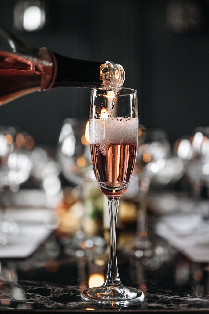 Close-up of sparkling wine being poured into a flute at a formal event setting.